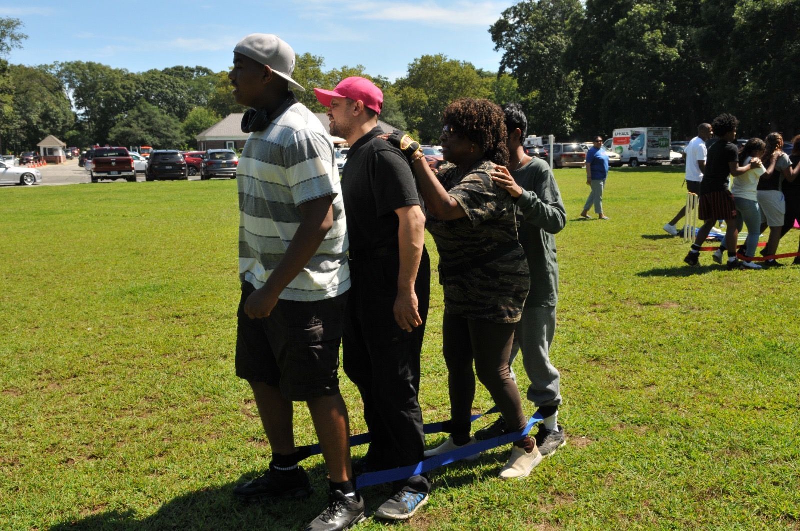 People standing in a line on a grassy field during an outdoor event