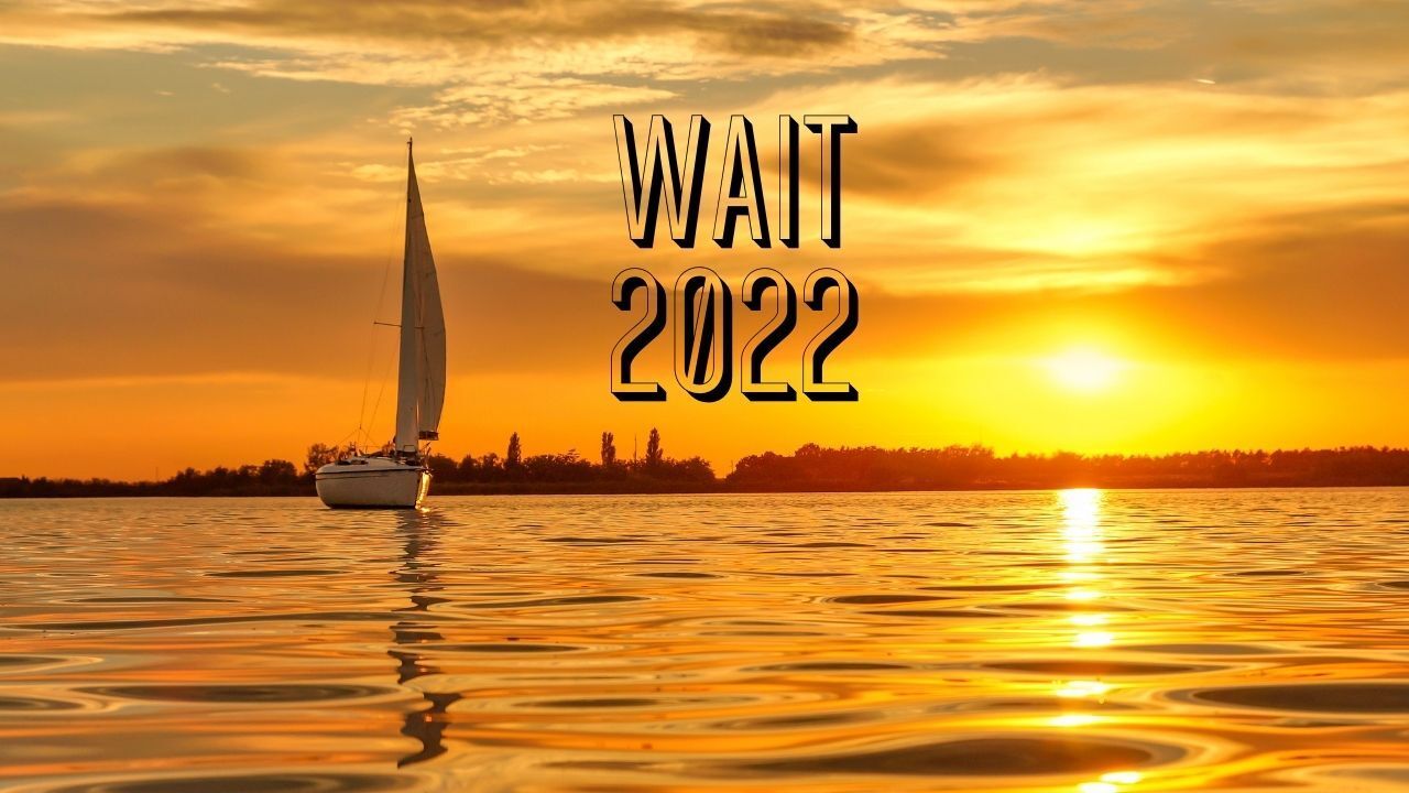 A sailboat is floating on top of a body of water at sunset.