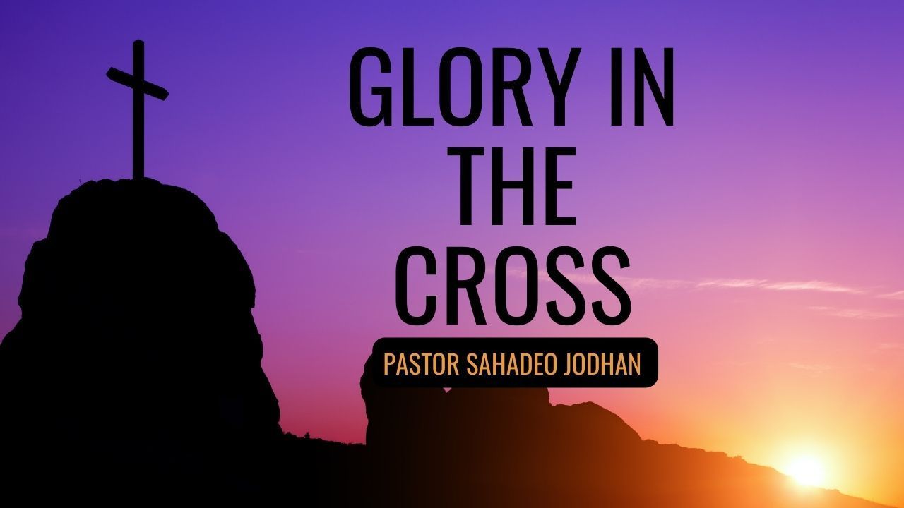 A silhouette of a person standing on top of a mountain with a cross on top of it.