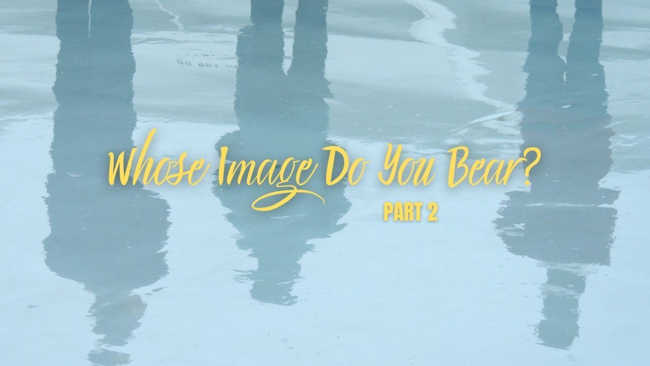 A group of people standing on a beach with their reflections in the water.
