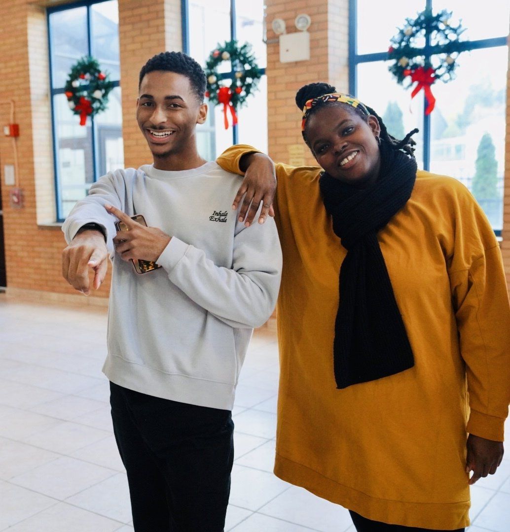 A man and a woman are posing for a picture and the man is pointing at the camera