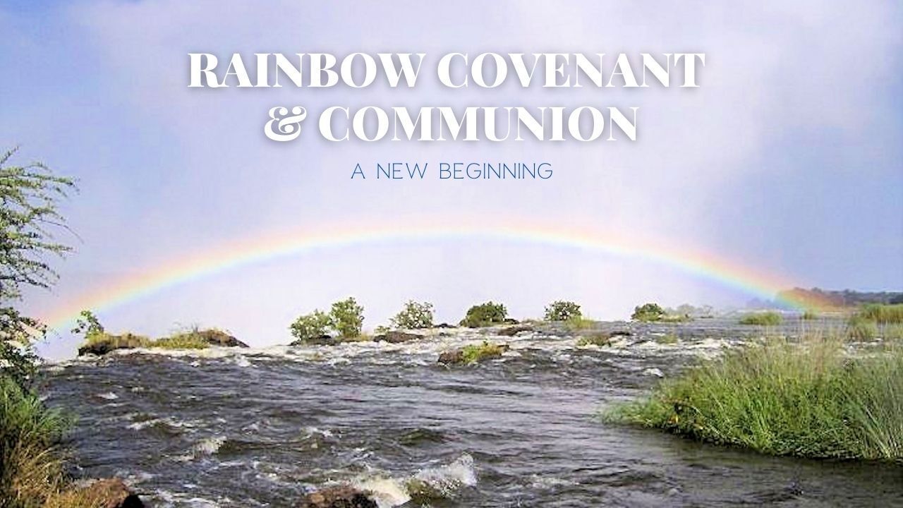 There is a rainbow in the sky over a river.