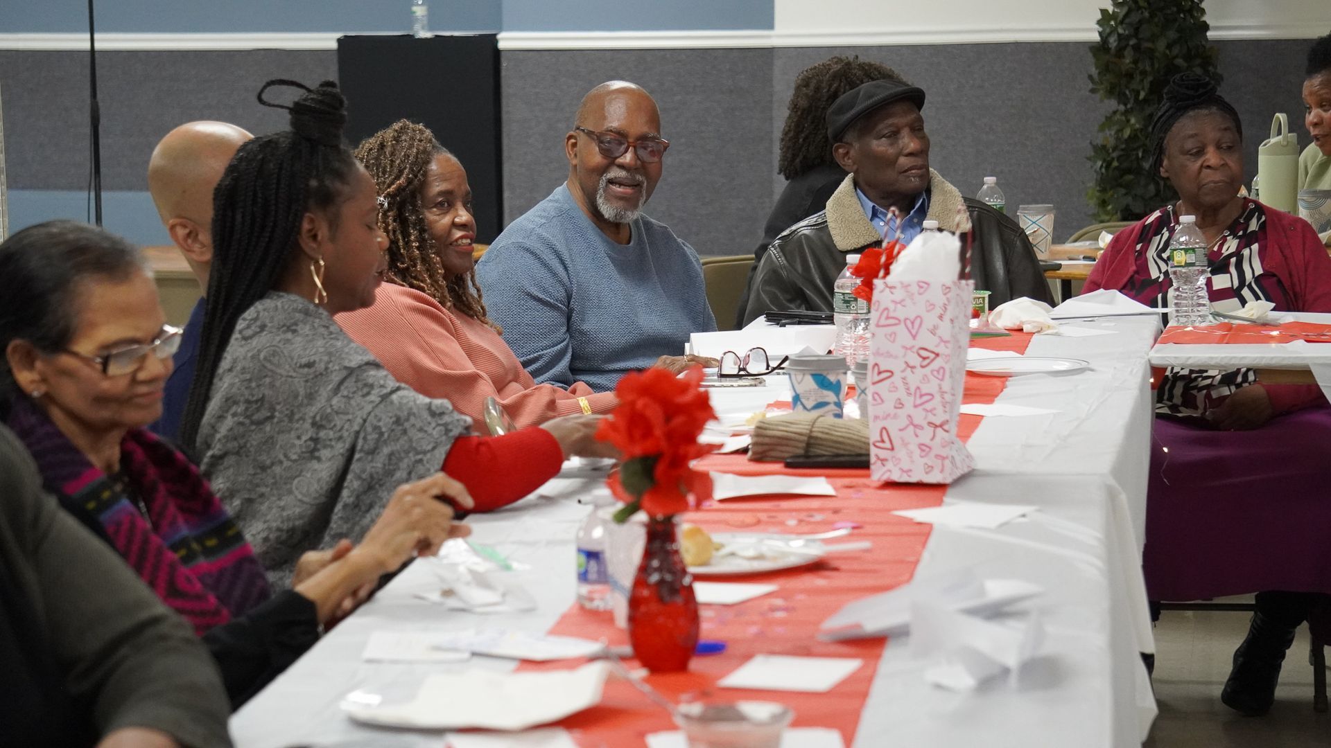 People seated at a decorated banquet table, looking toward someone off-camera at a community gathering. Marriage Ministry 2026