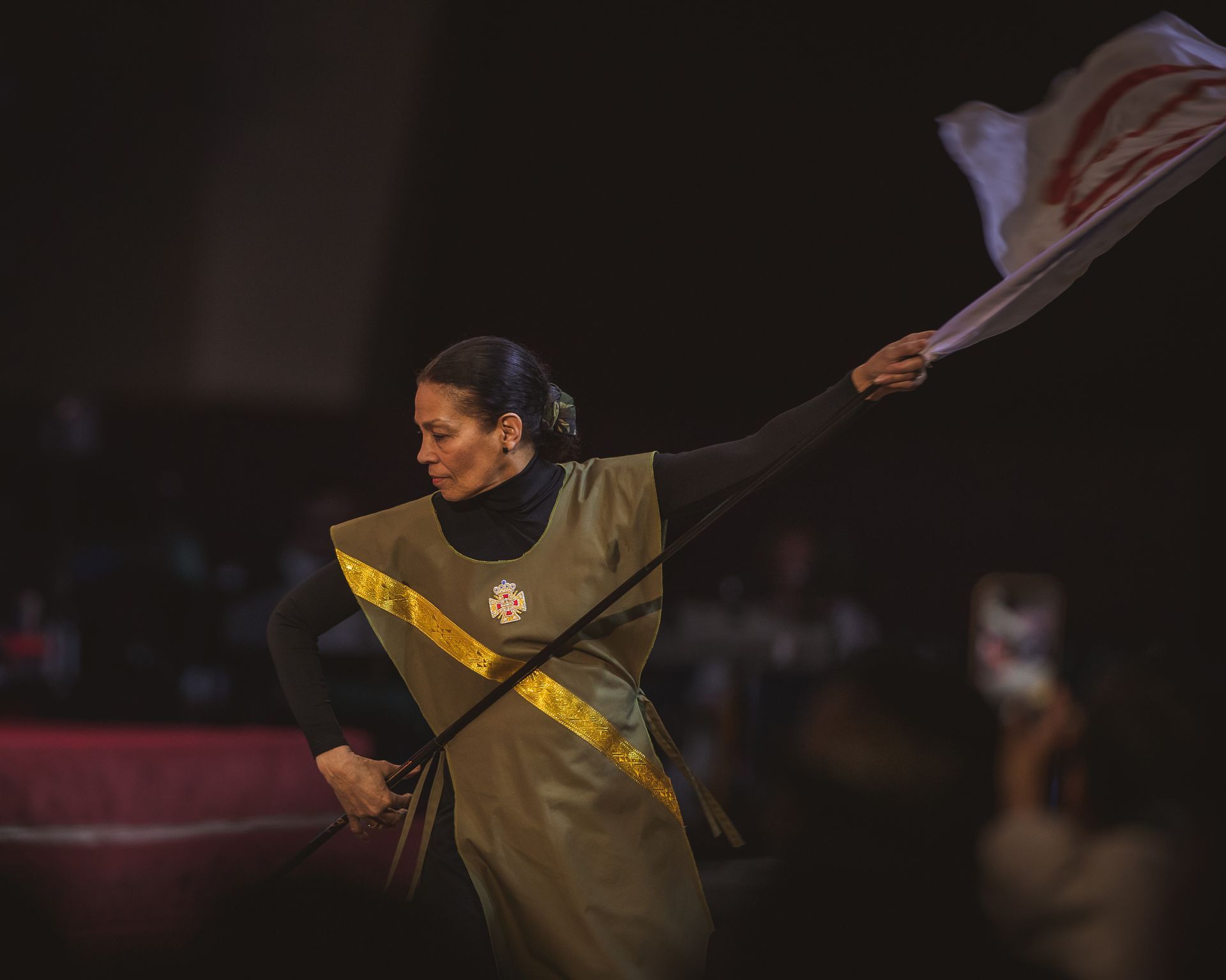 A woman in a green dress is holding a flag