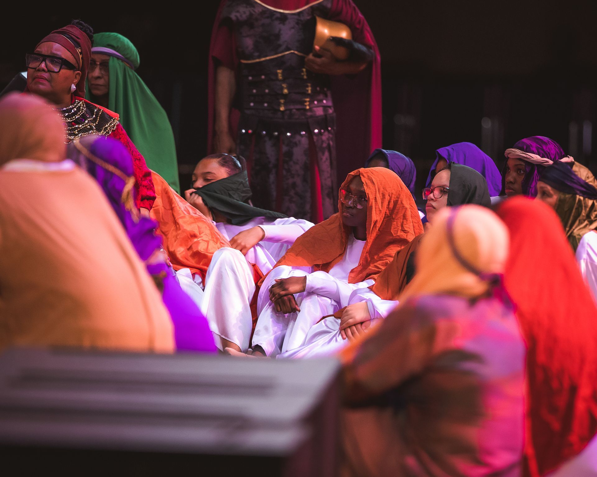 A group of people dressed in costumes are sitting around a table.