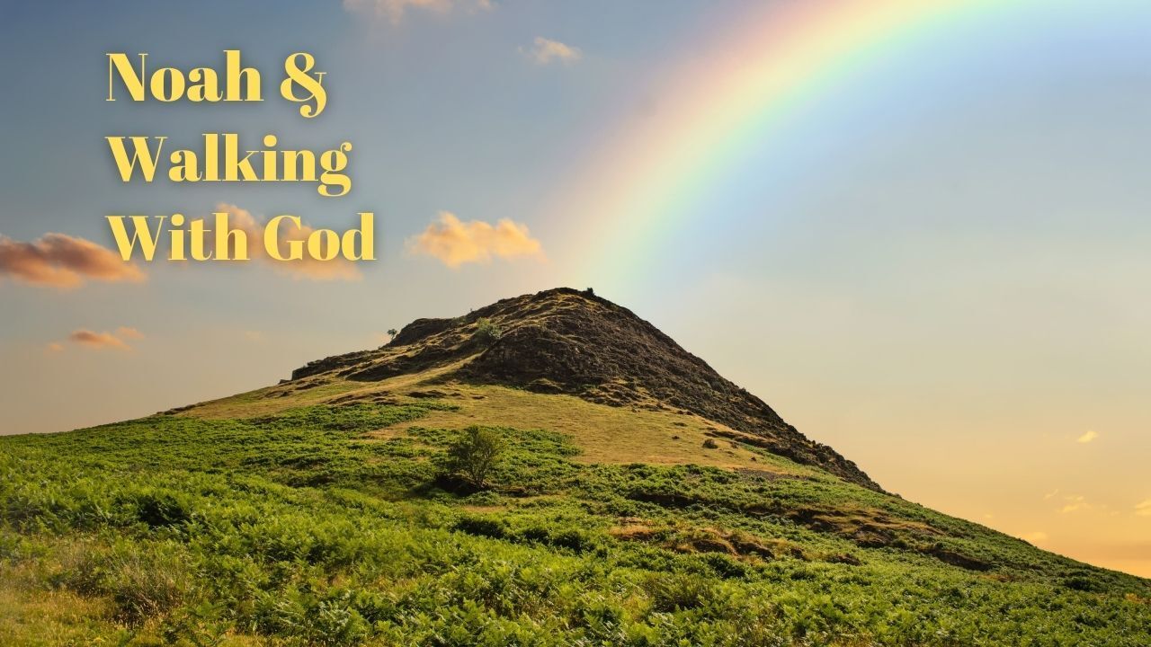 A mountain covered in grass with a rainbow in the sky.