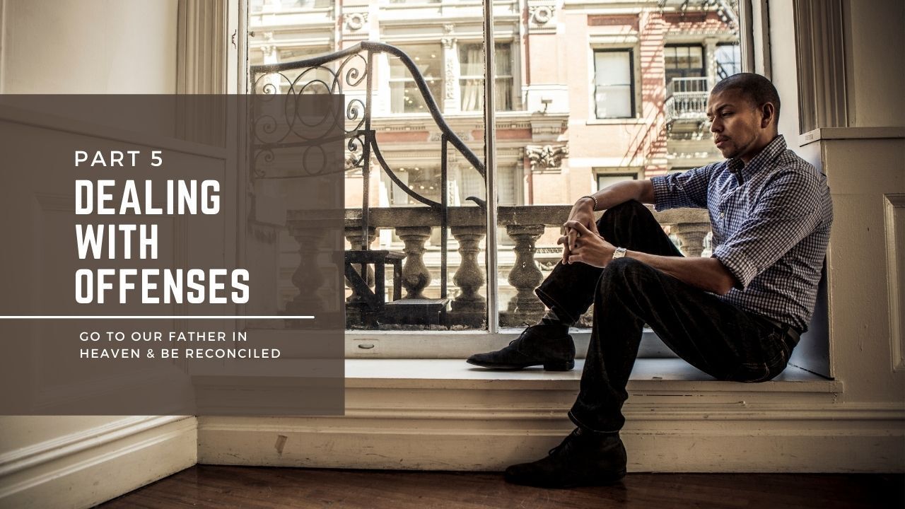 A man is sitting on a window sill in front of a window.