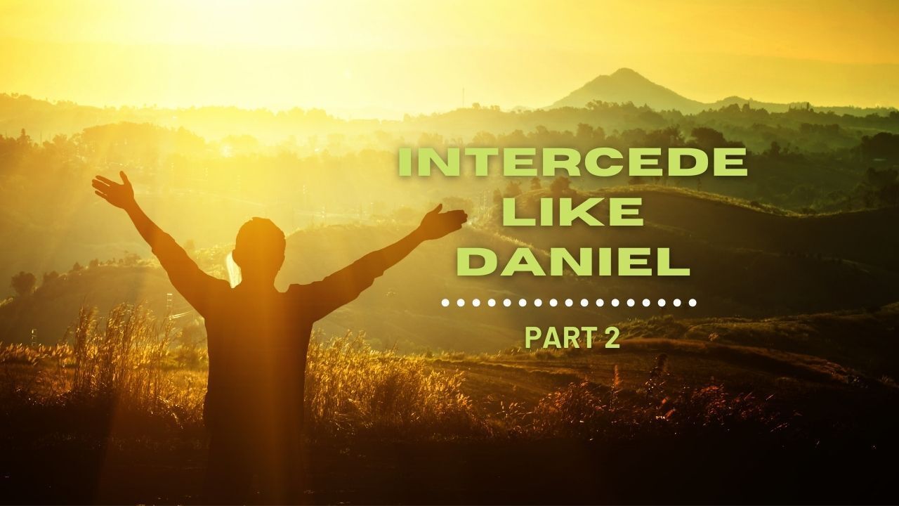 A man is standing in a field with his arms outstretched.