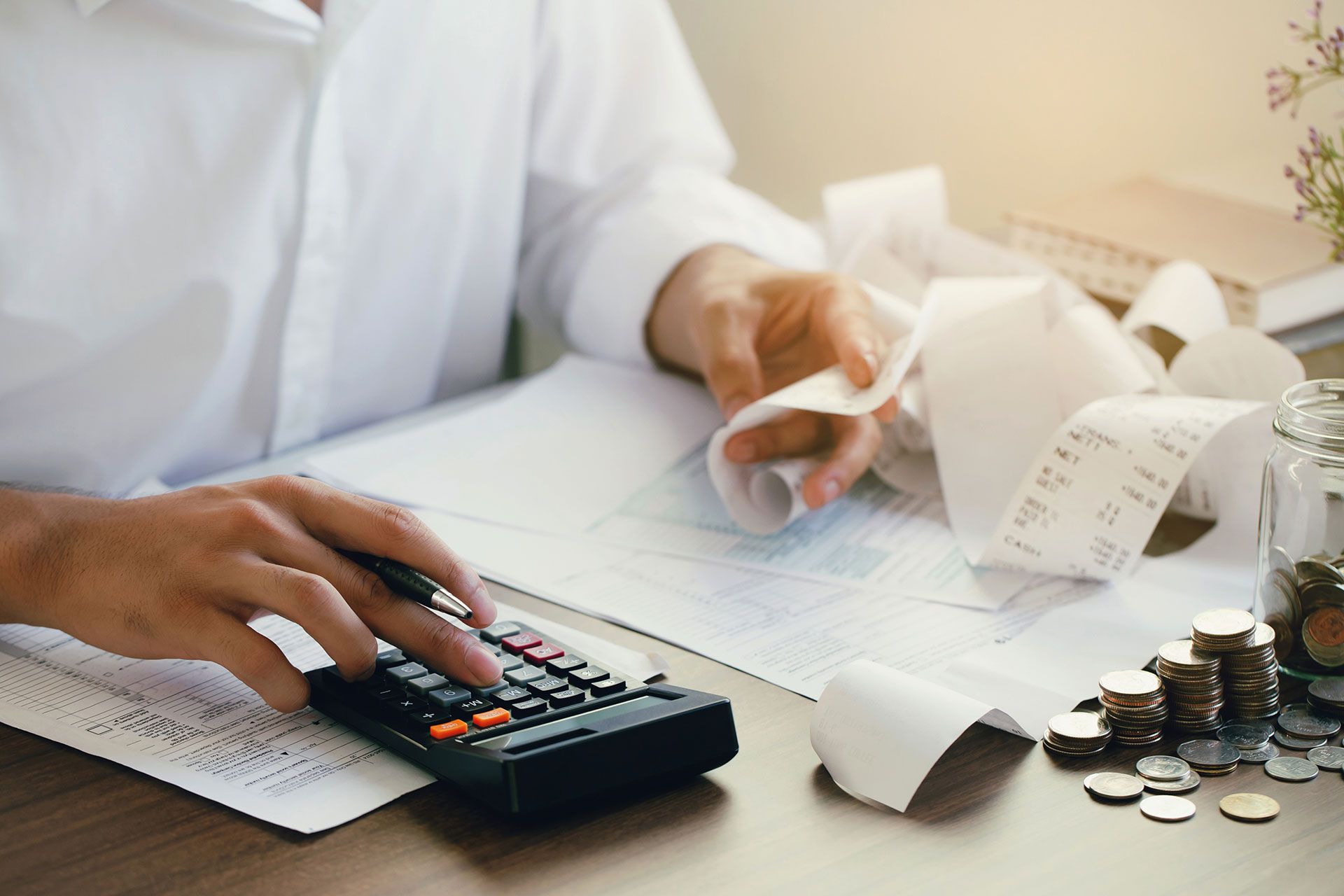 Man calculate domestic bills at home. Man using a calculator checking balance and costs at modern office.Business people doing paperwork for paying taxes.Expenses, account, taxes concept