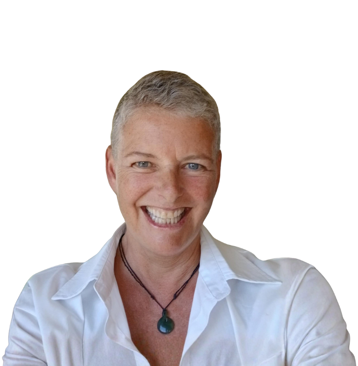 Woman with short gray hair, smiling widely, wearing a white shirt, indoors.