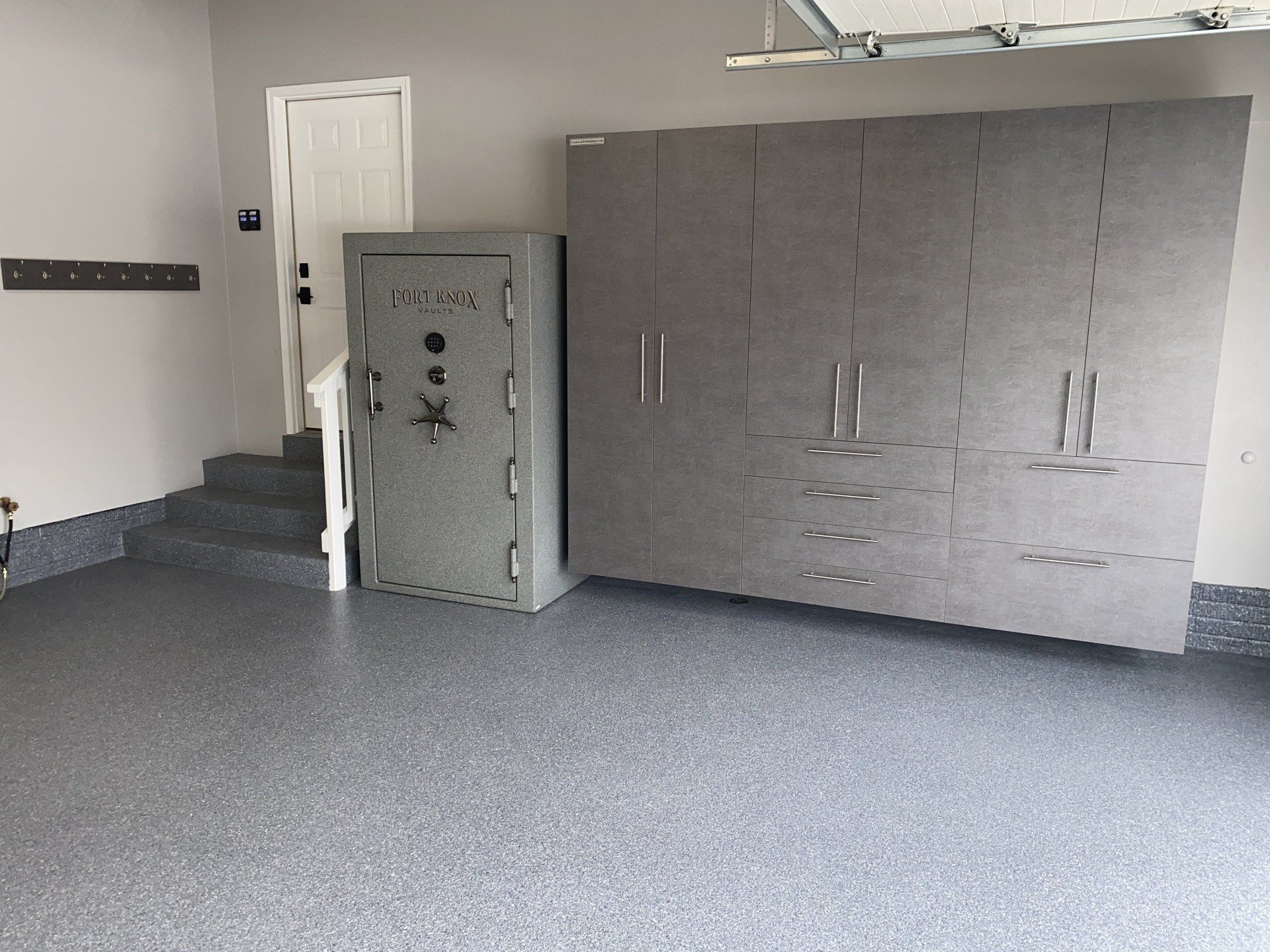 Gray polyaspartic garage floor with matching cabinet run and Fort Knox safe installed in a Cleveland