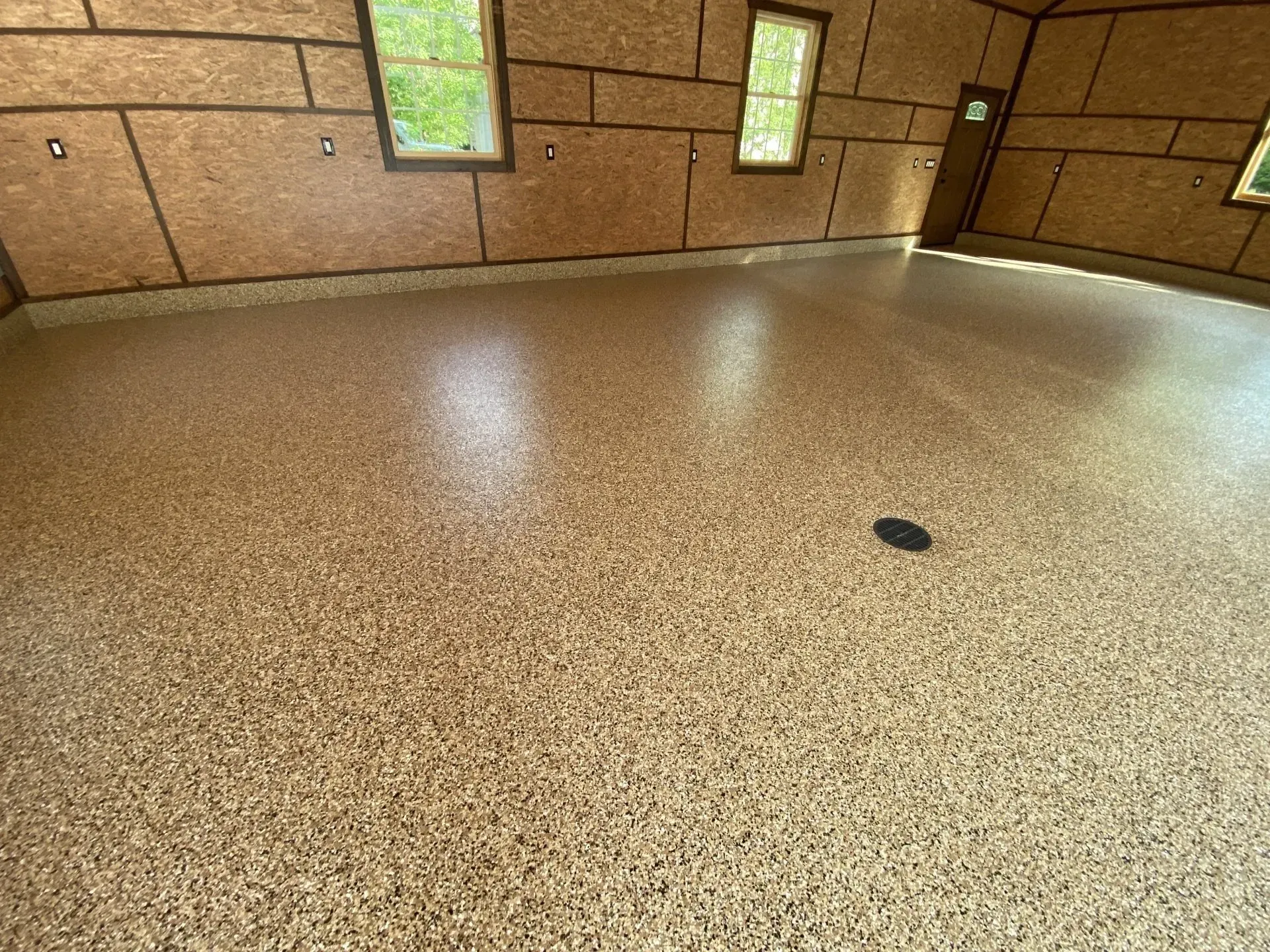 Finished tan polyaspartic garage floor coating installed before walls and cabinets in a Cleveland Oh