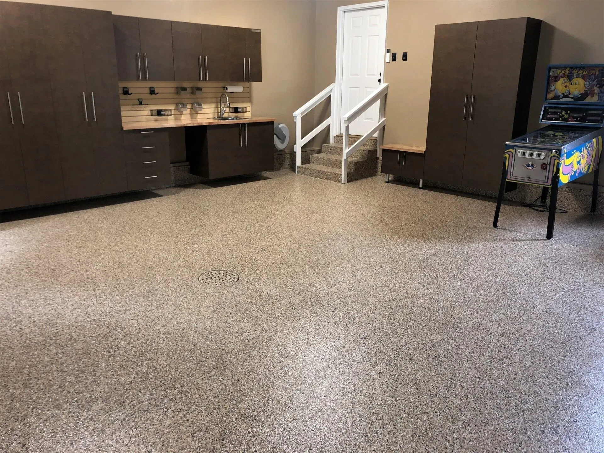 High-gloss polyaspartic floor coating with decorative flake reflecting light in a finished garage