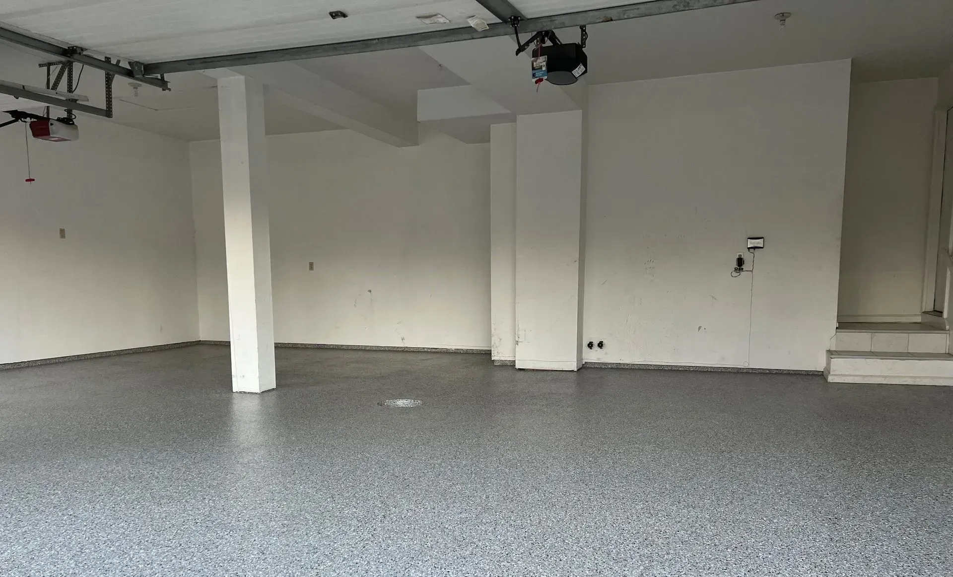 Professionally installed gray polyaspartic garage floor coating with decorative flake