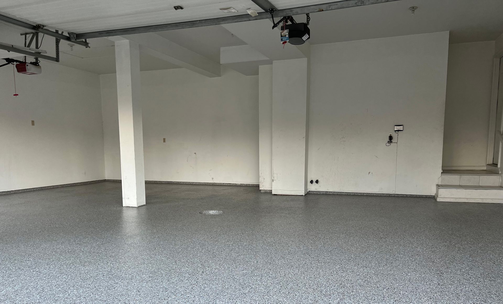 Gray flake polyaspartic floor in an empty two-car garage