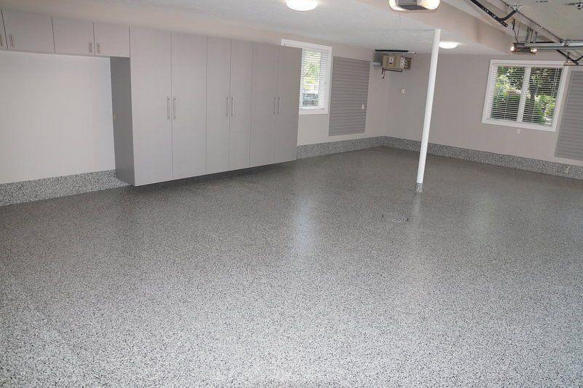 Garage with a gray flake coated floor and white wall cabinets, ready for a home gym