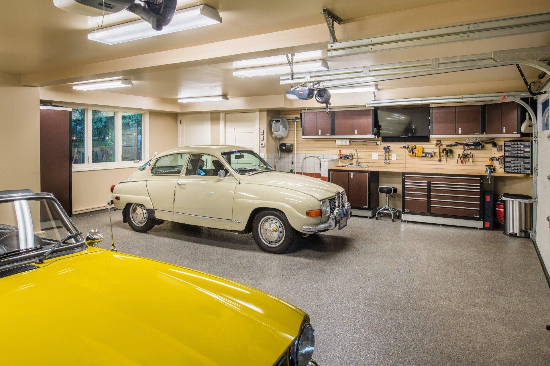 Finished garage workshop with a classic car, wood cabinets, and a long workbench