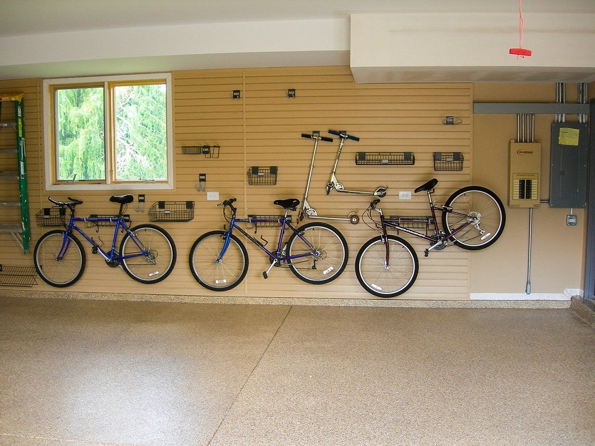 Slatwall with three bikes over a tan flake garage floor