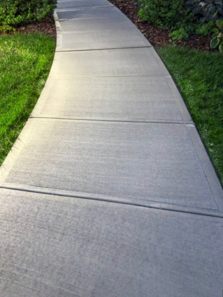 Curved Concrete Sidewalk Bordered by Green Grass and Shrubs — Outdoor Concreting in Townsville, QLD