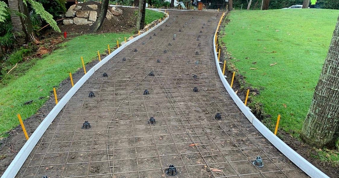 Curved Garden Path Bordered by White Edging — Outdoor Concreting in Townsville, QLD