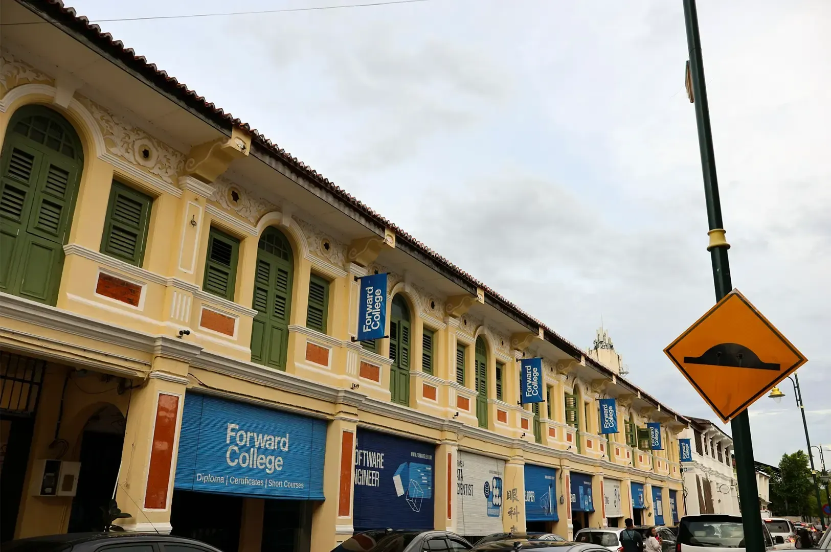 George Town heritage shophouses in Penang, Malaysia lined up in a busy street.