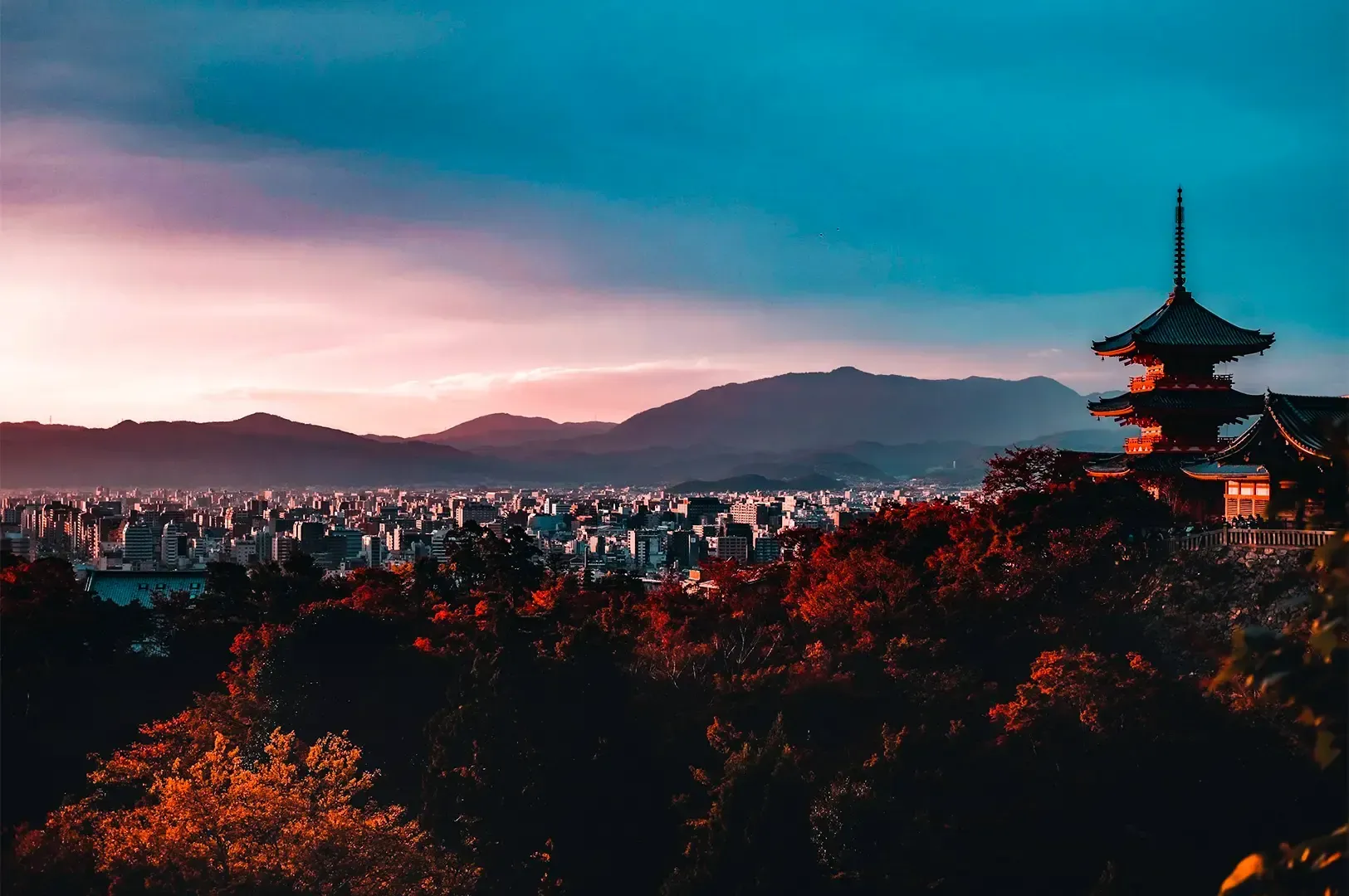 Kiyomizu-dera pagoda overlooking Kyoto city and mountains during autumn sunset, Japan