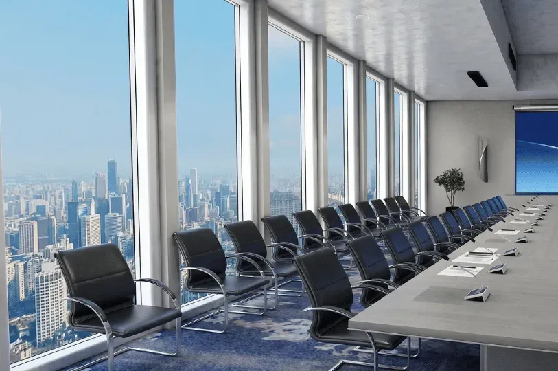 A modern, high-rise boardroom featuring a long conference table lined with black leather chairs and 