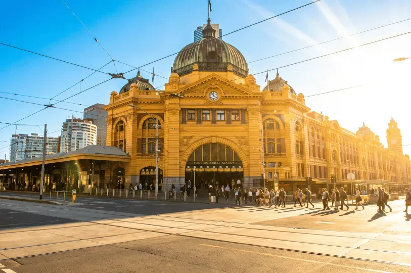 A wide-angle shot of the iconic yellow Victorian facade and central dome of Flinders Street Station 