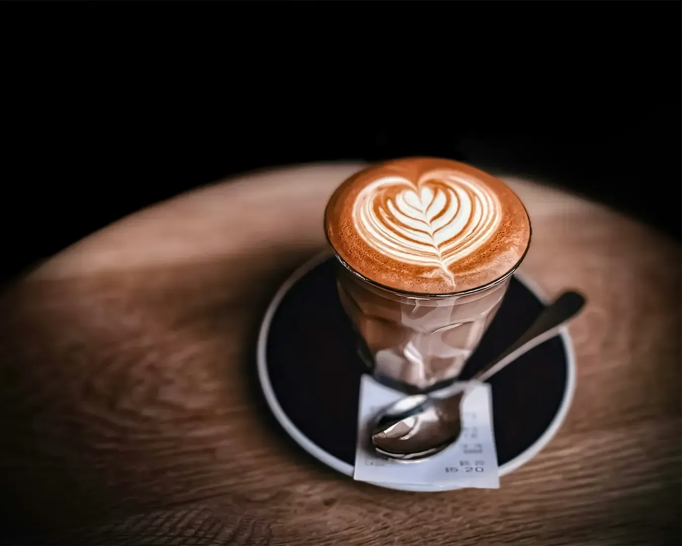 A freshly brewed cup of coffee topped with delicate latte art, creamy foam forming an elegant pattern on the surface of the espresso.