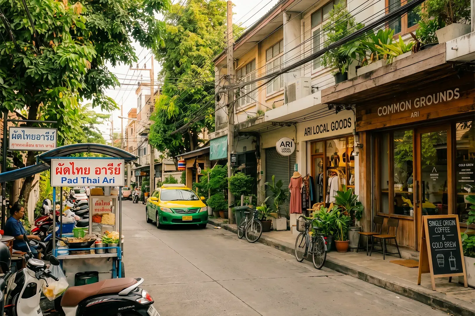 A narrow street along Ari with shops on the right side and a vendor stand on the left.
