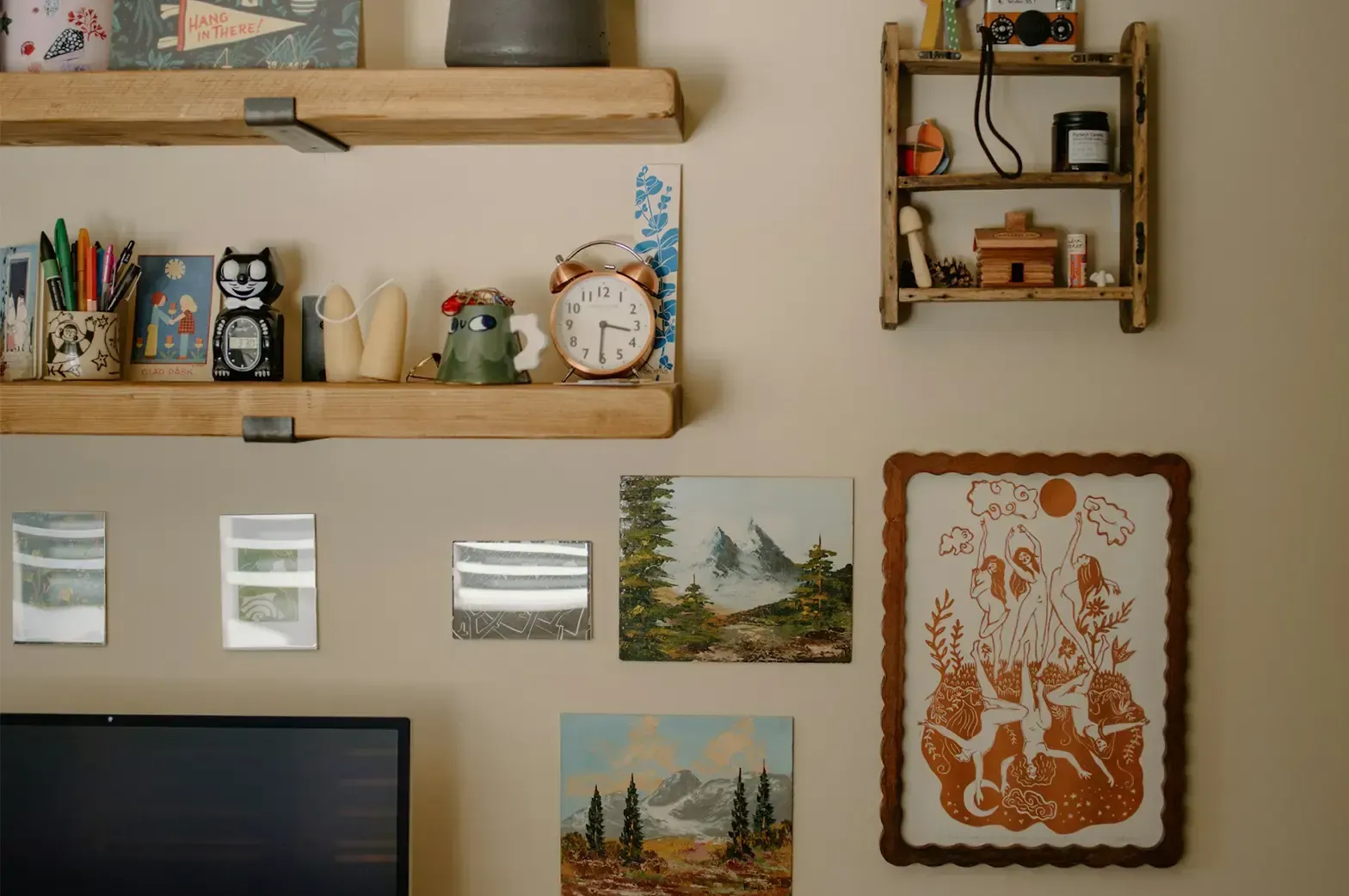 A white wall filled with decorations of picture frames, pencil case, and other personal items.
