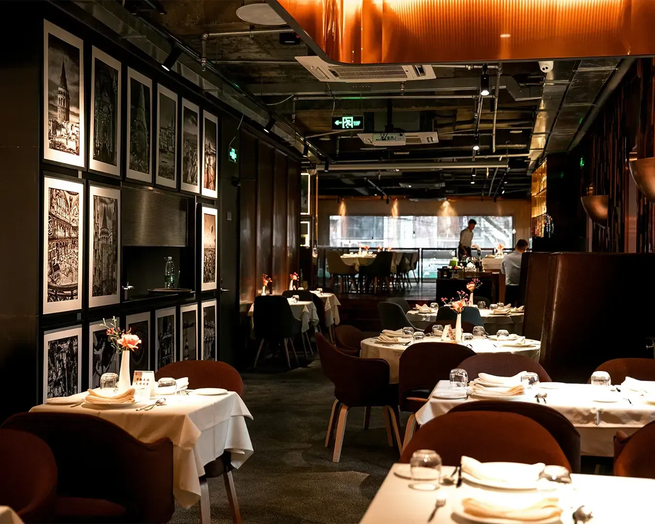 A stylish restaurant interior featuring neatly arranged dining tables, ambient lighting, and elegant décor that creates a welcoming and refined dining atmosphere.