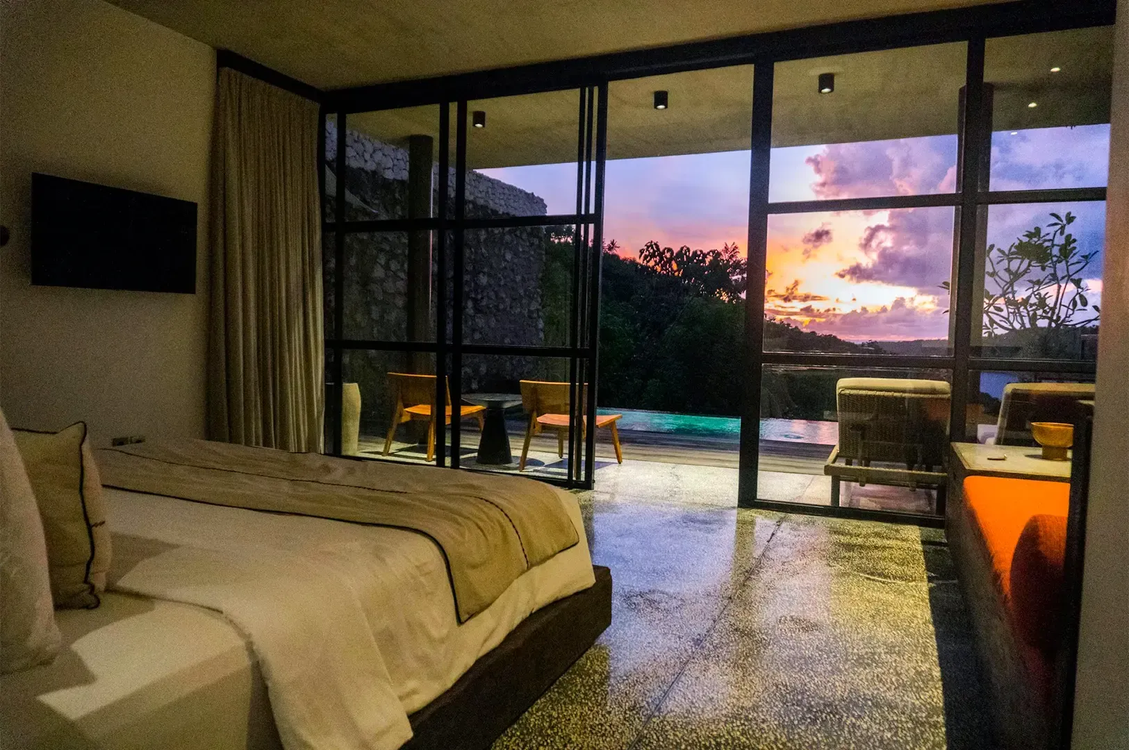 An open hotel room with a sunset view in the horizon.