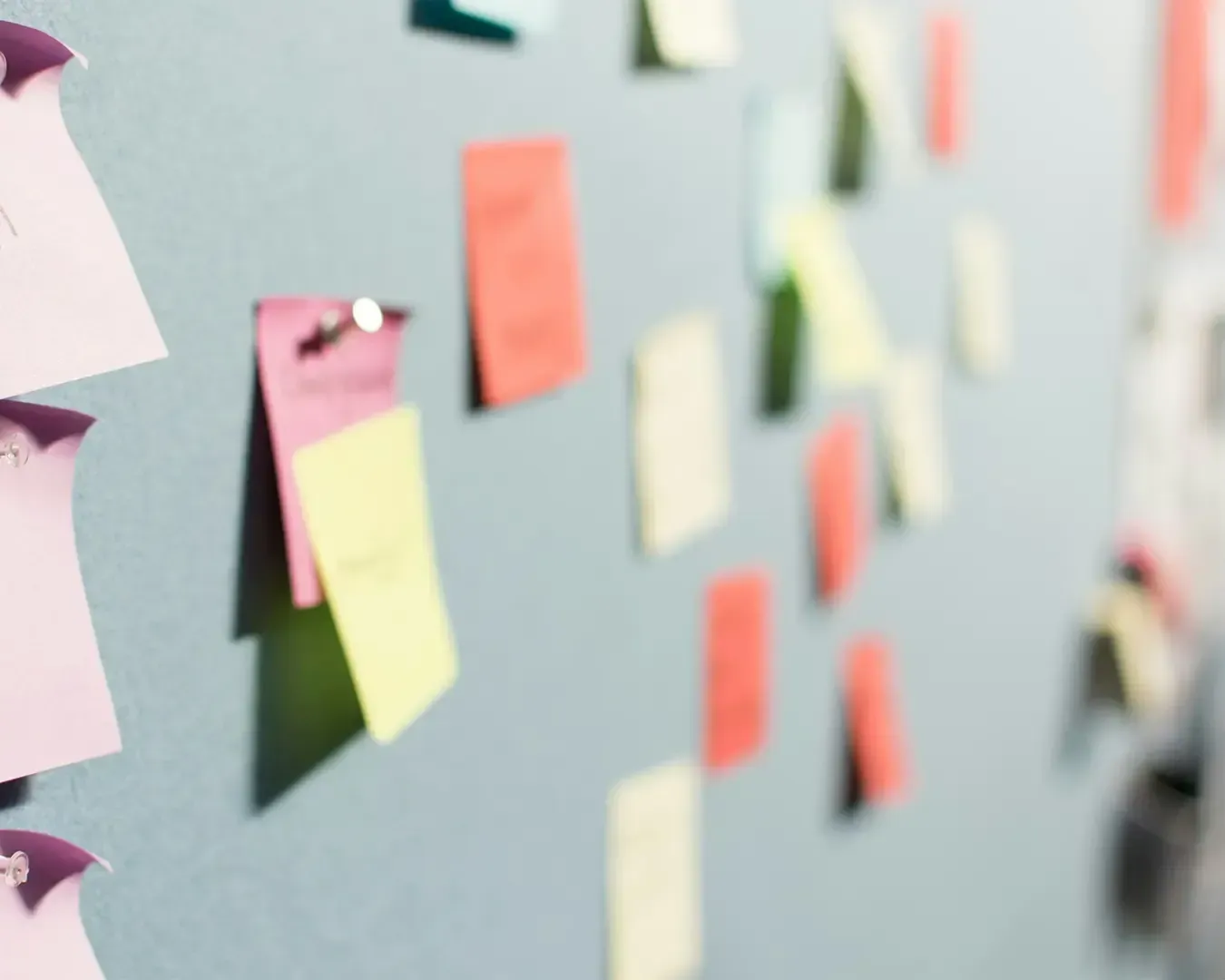 A board filled with many colourful sticky notes arranged across the surface. The notes suggest brainstorming, planning, or organising ideas, creating a visual map of tasks, reminders, or creative concepts.