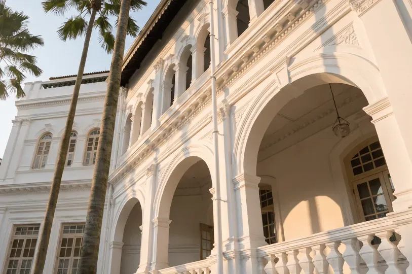 Elegant white architectural arches and balustrades of a historic luxury hotel glowing in soft golden hour light, establishing a refined and historic sense of place upon arrival.