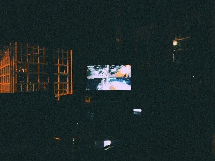 The Midnight Concierge : Hotel concierge reviewing CCTV footage late at night with focused determination.