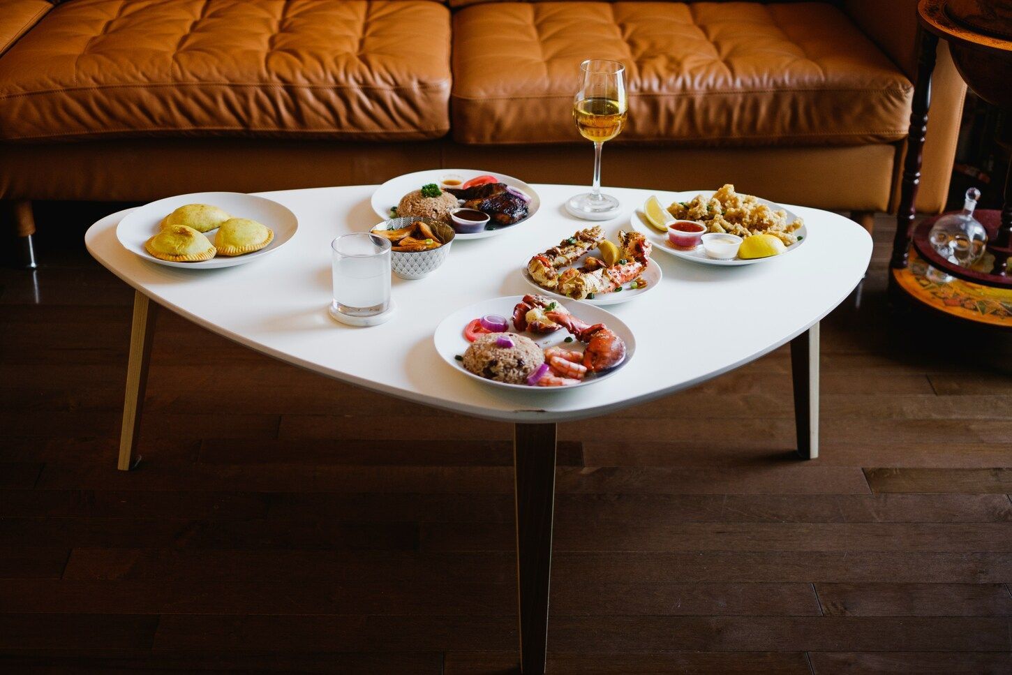 Private Dining Experiences : Elegant hotel room setup with gourmet dishes served on a white-linen table by the window.