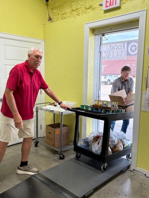 Two men are looking into a freezer in a store.