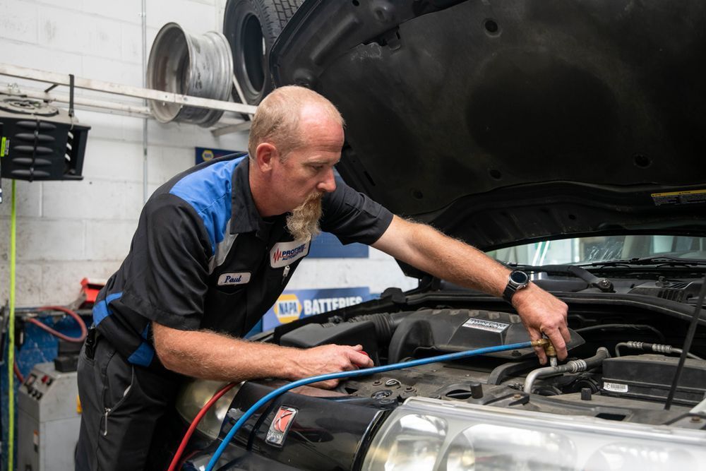 Technician Inspecting Vehicle Engine Bay | Protime Automotive