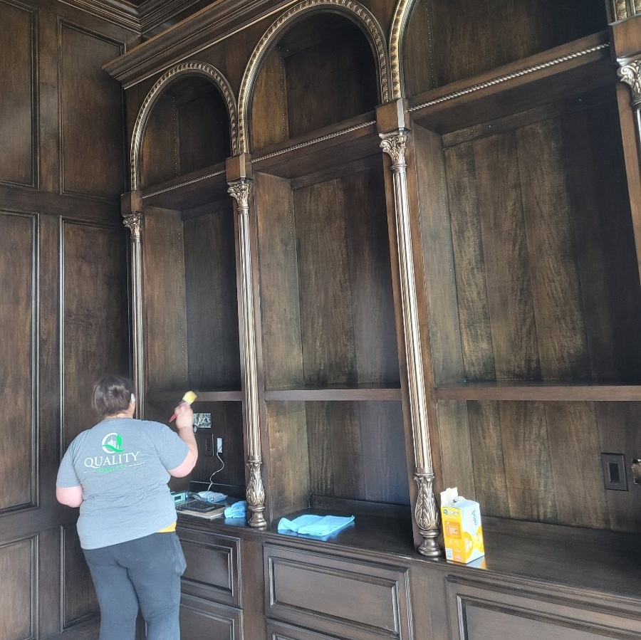 A woman wearing a quality shirt is cleaning shelves