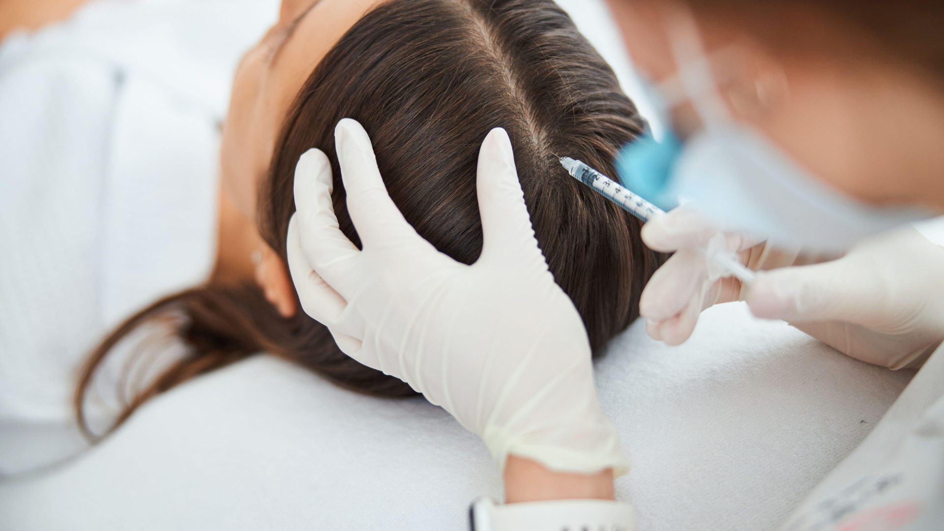 A woman is getting an injection in her hair.