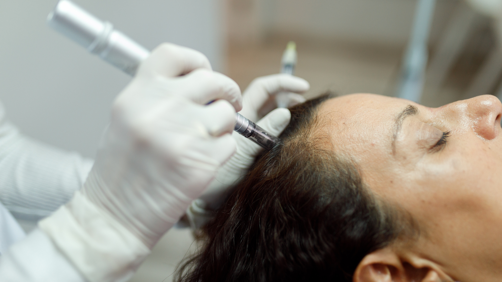 A woman is getting a hair treatment at a salon.