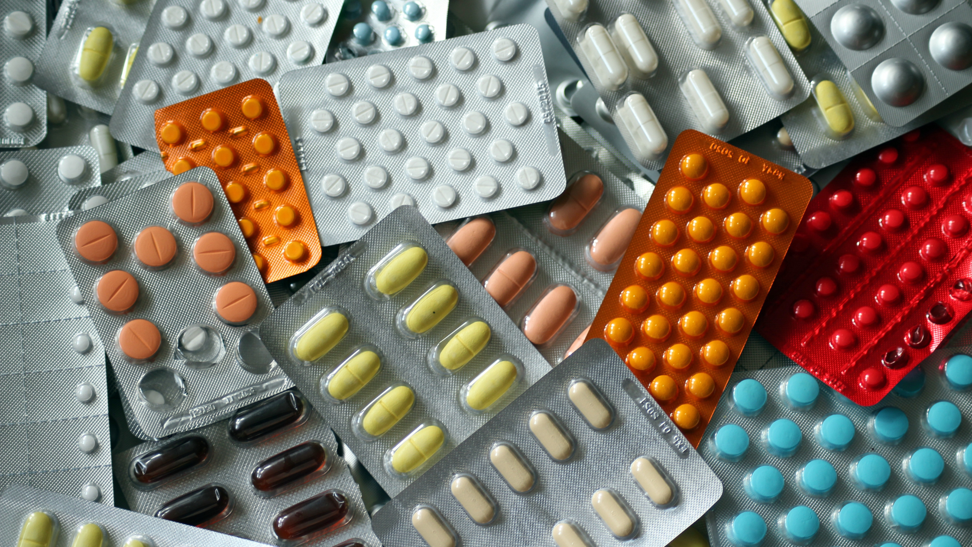 A bunch of different types of pills in blister packs