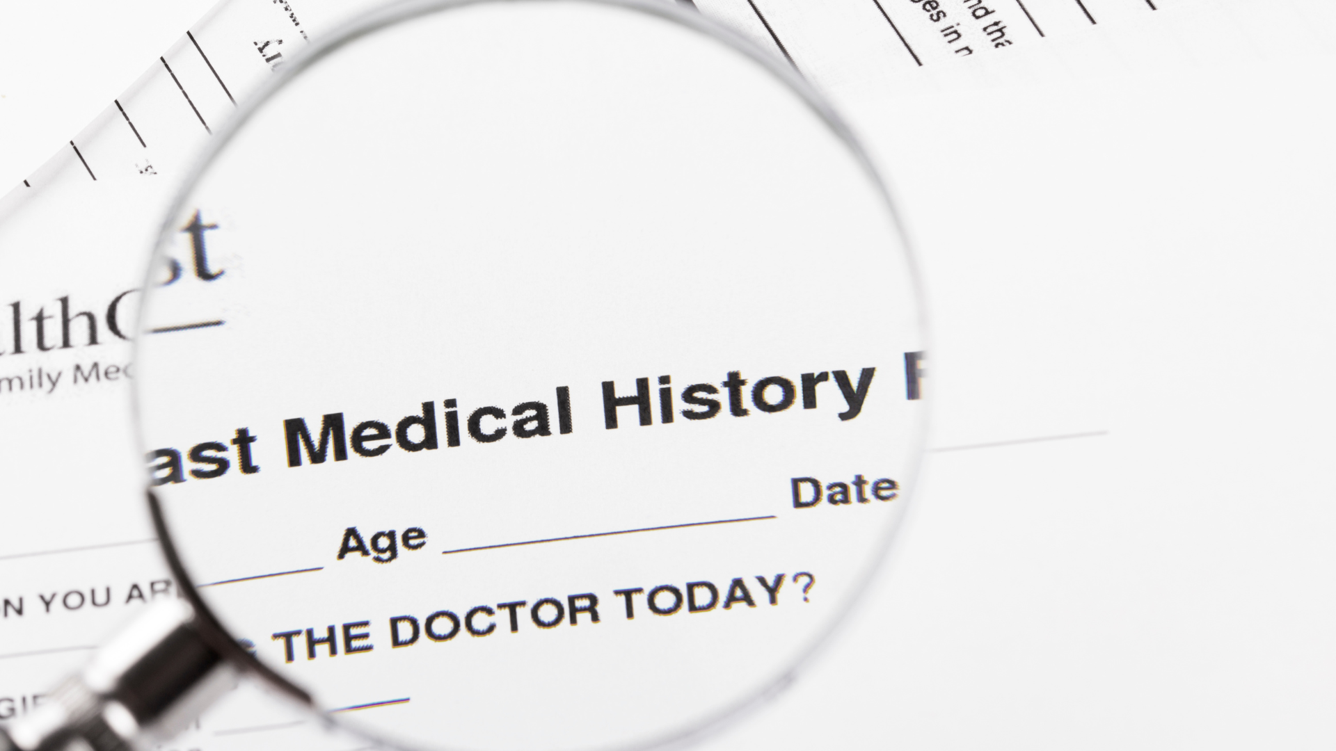 A magnifying glass is looking at a medical history form