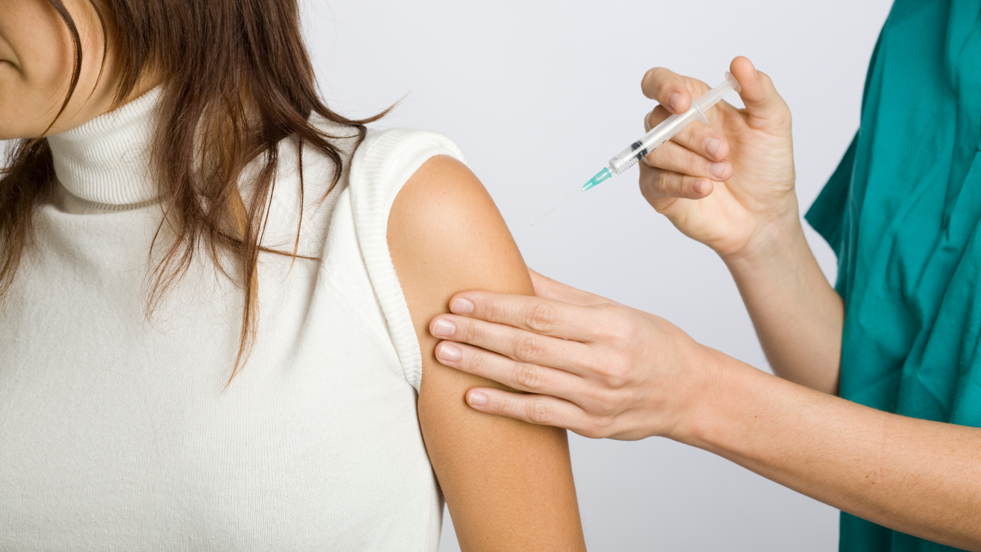 A woman is getting an injection in her arm.