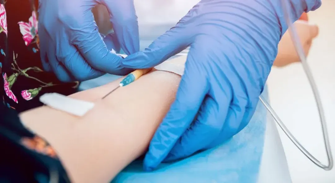 A close up of a person getting an injection in their arm.