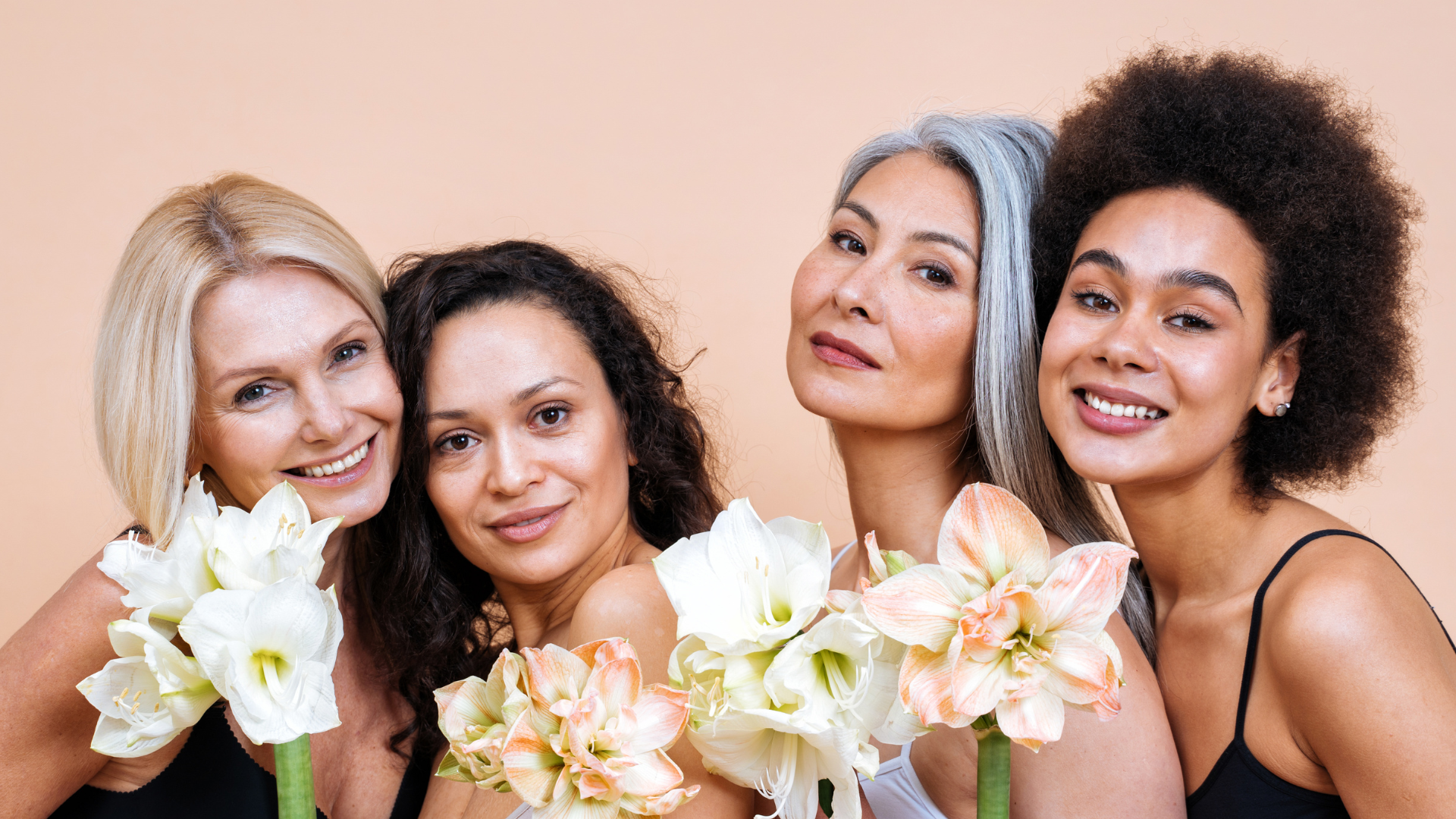 A group of women are posing for a picture while holding flowers.