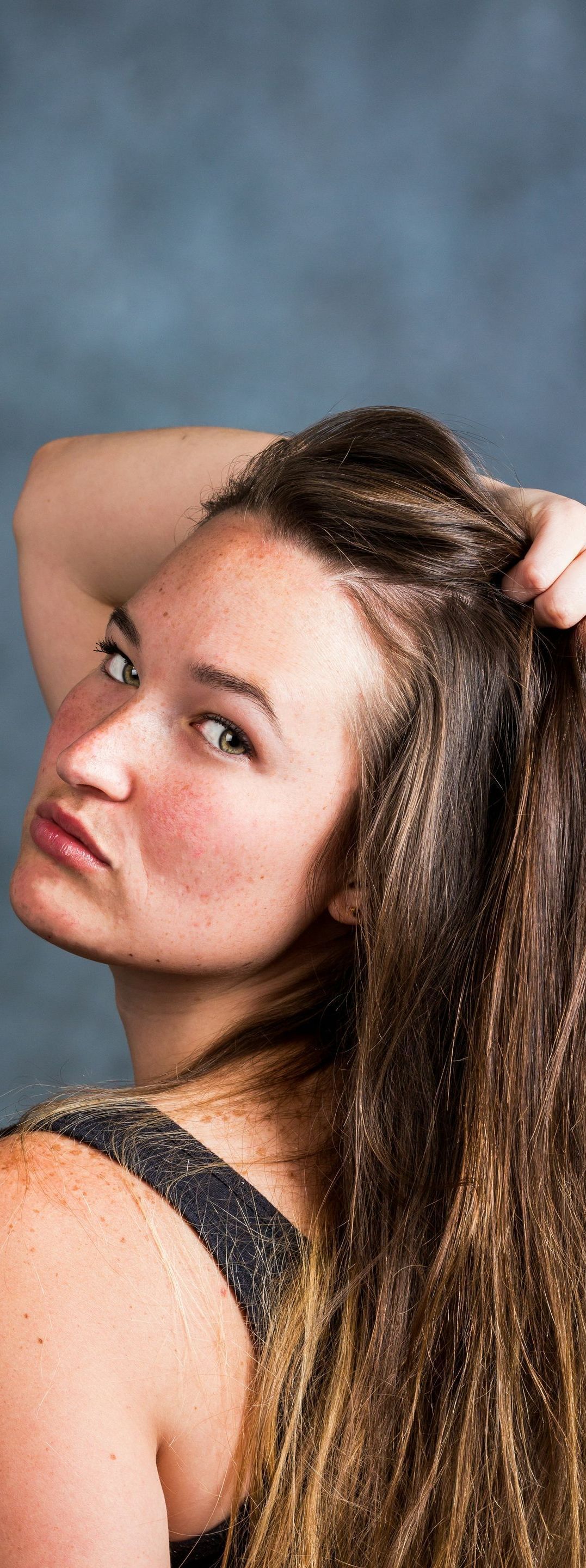 A woman with dreadlocks is holding her hair in her hand.