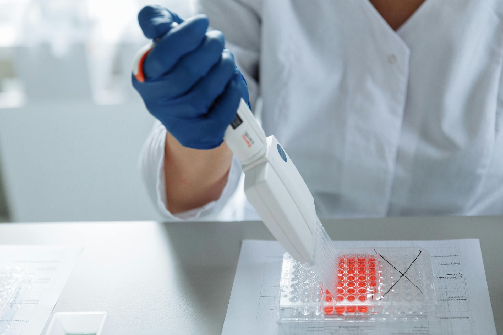 A scientist is using a pipette to pour liquid into a test tube.