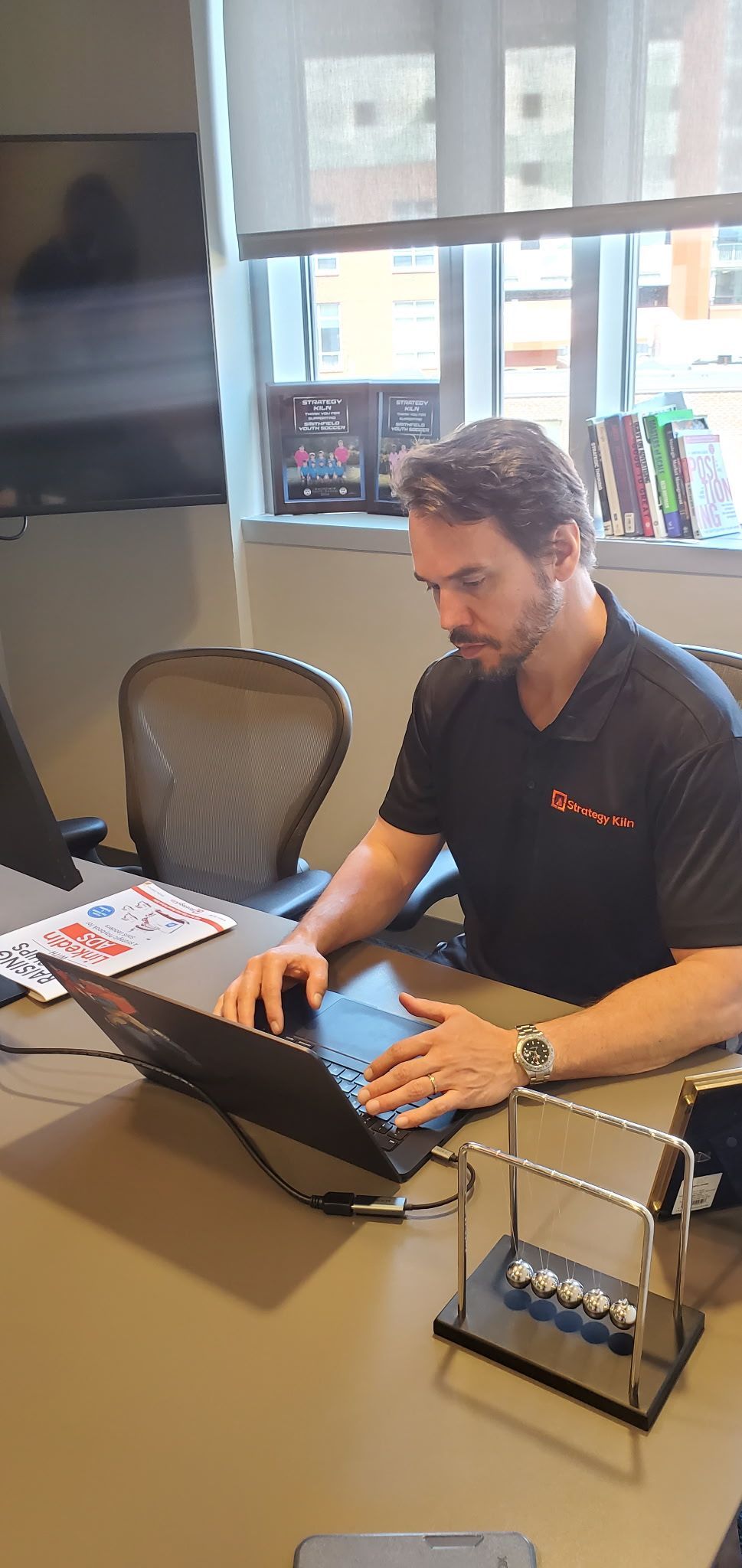 Adam Fischer working at his desk in the Strategy Kiln Providence office